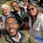 A group of happy church members pose for a selfie on a sunny day